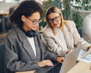 Two people working together on a laptop.