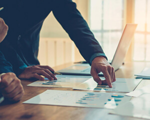 Man pointing to a chart on a piece of paper.